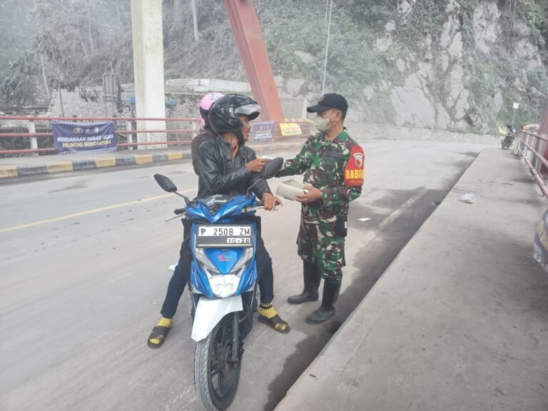 Babinsa Sumberwuluh Amankan Lalin dan Lindungi Pengendara dengan Pembagian Masker 